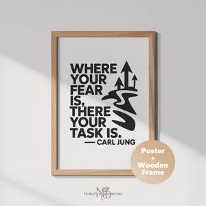Könnte beinhalten: Gerahmtes Poster mit hellem Holzrahmen. Das Poster zeigt das Zitat "WHERE YOUR FEAR IS, THERE YOUR TASK IS." in schwarzem Text, zugeschrieben Carl Jung. Das Design umfasst stilisierte Pfeile und einen gewundenen Pfad.