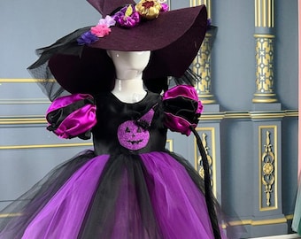 May include: A purple and black tulle tutu dress with a black cat tail, a black bodice with a glitter pumpkin design, and a purple witch hat with flowers and a gold pumpkin accent.