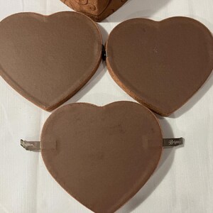 May include: A white ceramic mug with a black handle and the text "But First, Coffee" in a bold, black font. The mug is set against a blurred background, suggesting a cozy setting.