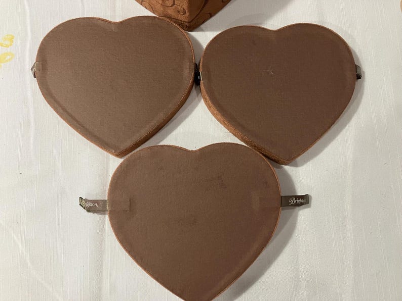 May include: A white ceramic mug with a black handle and the text "But First, Coffee" in a bold, black font. The mug is set against a blurred background, suggesting a cozy setting.