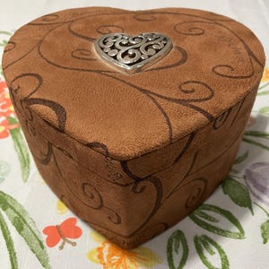 May include: A set of three ceramic canisters with lids. The canisters are white with a blue floral pattern. The largest canister is 8 inches tall, the medium is 7 inches, and the smallest is 6 inches.