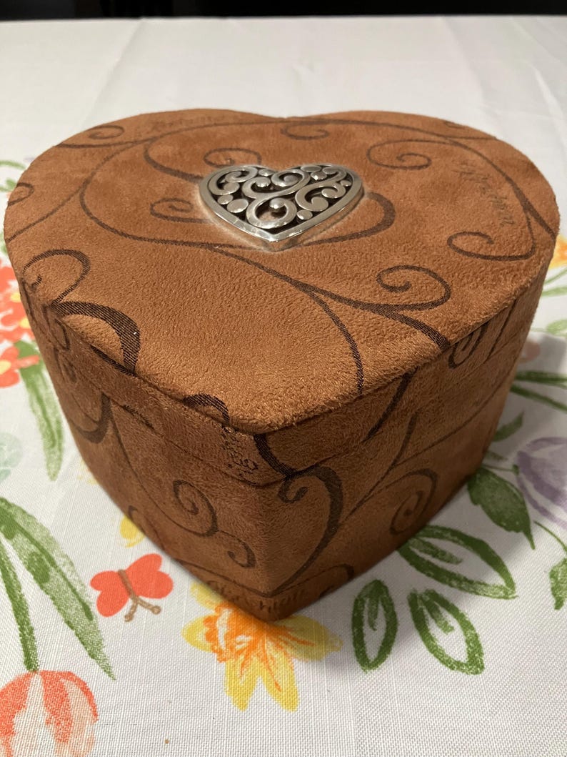 May include: A set of three ceramic canisters with lids. The canisters are white with a blue floral pattern. The largest canister is 8 inches tall, the medium is 7 inches, and the smallest is 6 inches.