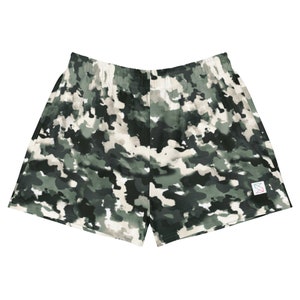 May include: Camouflage print shorts with a small logo on the right side. The shorts are a dark green, white, and black color.