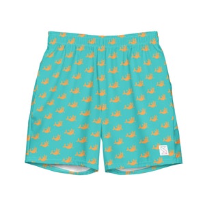 May include: Teal blue athletic shorts with a repeating pattern of orange fish. The shorts have a white elastic waistband and a white drawstring.