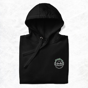 May include: Black hooded sweatshirt with a green and white cartoon face graphic on the front.
