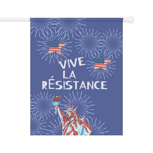 Peut inclure: Un drapeau bleu avec le texte "VIVE LA R&Eacute;SISTANCE", des illustrations de feux d'artifice, des &eacute;toiles avec des motifs de drapeau am&eacute;ricain et la Statue de la Libert&eacute;. Le drapeau est mont&eacute; sur un poteau blanc.