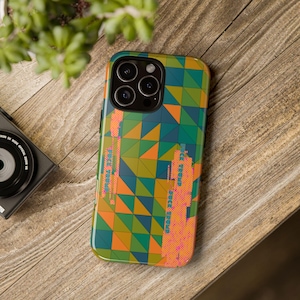 May include: A colorful phone case with a geometric pattern of triangles in shades of green, orange, and blue. The case has a camera cutout and a design that resembles a cityscape. The case is on a wooden surface.