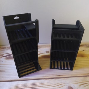 May include: Two black plastic storage organisers with multiple compartments. Each organiser has a rectangular shape and is made of black plastic. The organisers are empty and are sitting on a wooden surface.