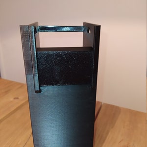 Könnte beinhalten: Eine schwarze Plastikbox, die im 3D-Druck hergestellt wurde, mit einer rechteckigen Öffnung oben. Die Box hat eine glatte, matte Oberfläche.