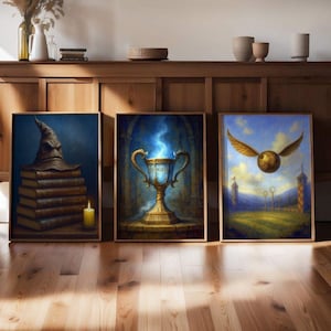 Puede incluir: Tres impresiones artísticas enmarcadas con temas de fantasía. Una representa un sombrero seleccionador sobre libros, otra una copa dorada con llamas azules y la tercera una snitch dorada volando.