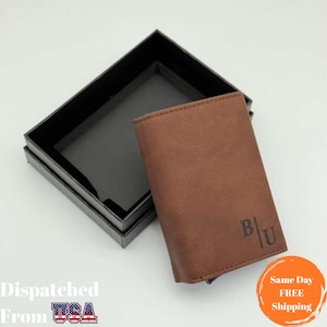 May include: A brown leather wallet with the initials "B|U" embossed on the front. The wallet is displayed next to an open black box. The image also includes text that reads "Dispatched From USA" and "Same Day FREE Shipping".