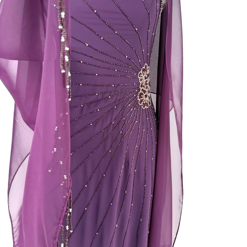 Detail view of the purple chiffon gown, draped with a sheer shawl with beaded edges.