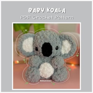 Puede incluir: Un koala de ganchillo gris hecho a mano con detalles blancos en las orejas y el vientre. El koala tiene una nariz y ojos negros. El texto "BABY KOALA PDF Crochet Pattern" está en la parte superior de la imagen.