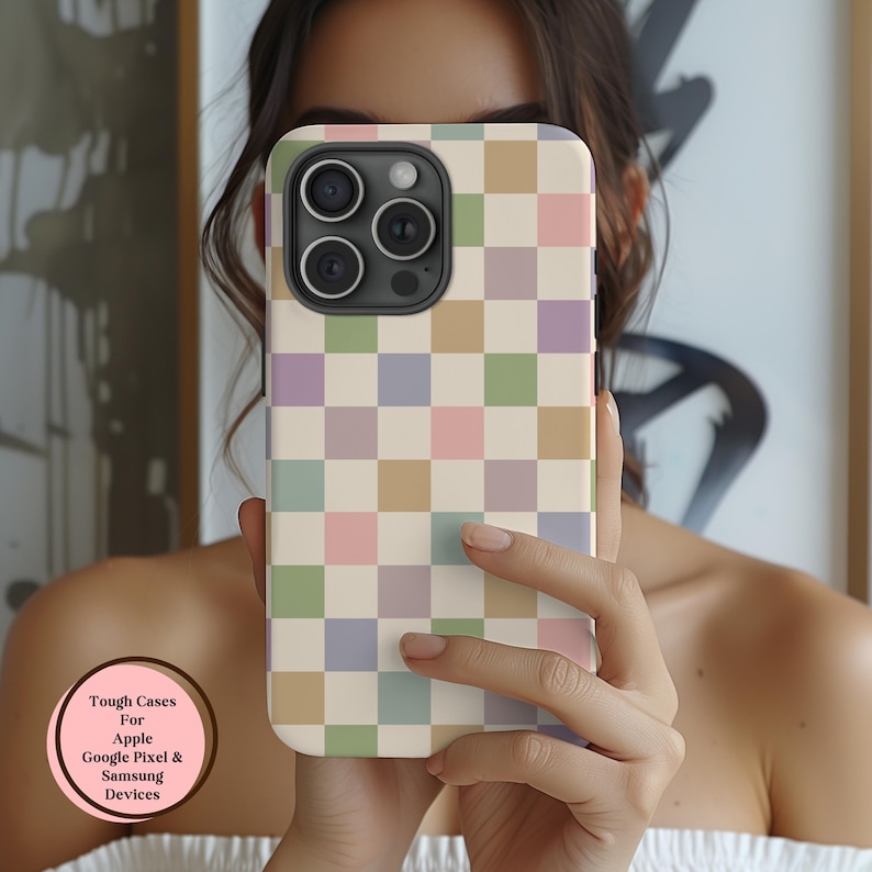 Puede incluir: Una funda de tel&eacute;fono con un dise&ntilde;o de tablero de ajedrez en tonos pastel en rosa, verde, morado y beige. La funda est&aacute; en un tel&eacute;fono con m&uacute;ltiples lentes de c&aacute;mara. El texto en la funda dice "Tough Cases For Apple Google Pixel & Samsung Devices."