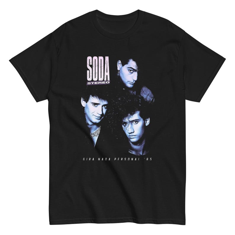 May include: A black short-sleeve t-shirt featuring a blue-toned graphic print of three individuals. The text SODA STEREO is printed in white above the figures, and the text GIRA NADA PERSONAL '85 is printed in white below the figures on the chest.