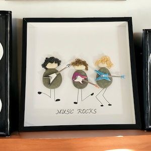 Music Rocks Pebble Art Trio-band. Framemaat is 12 x 12 inch. Handgemaakte kiezelkunst voor de muziekliefhebber, grappig kiezelkunstcadeau