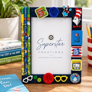 May include: A dark blue picture frame decorated with Dr. Seuss themed embellishments, including two pencils on the left side, various character cutouts, colorful buttons, and heart-shaped glasses. The center displays the text Superstar Creations.