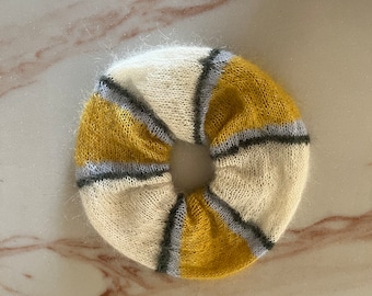 May include: A white and yellow striped knitted hair scrunchie with a gray stripe.