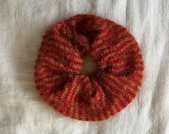 May include: A red and gold striped scrunchie made of fuzzy yarn.