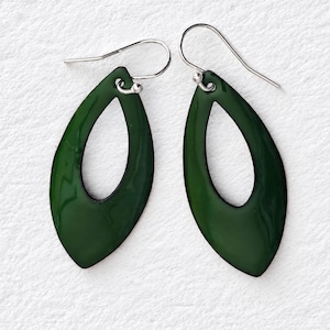 May include: A pair of dark forest green teardrop-shaped earrings with a smooth, glossy finish. Each earring features a central open cutout and is suspended from a simple silver-toned metal hook wire, providing a clean and balanced appearance.