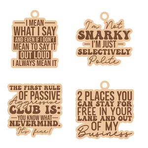May include: Four wooden decorative tags with humorous quotes in brown text. The quotes include "I mean what I say", "I'm not snarky", "The first rule of passive aggressive club is", and "2 places you can stay for free".