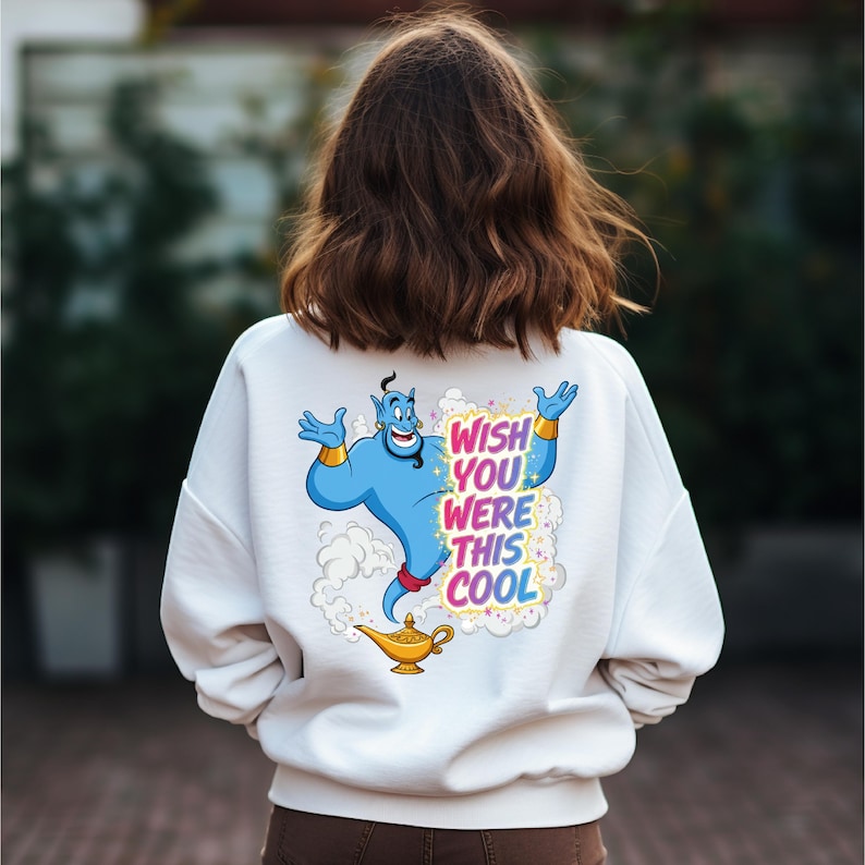 May include: White sweatshirt with a colorful graphic of a blue genie with gold bracelets and a magic lamp. The text "WISH YOU WERE THIS COOL" is printed in a rainbow font.