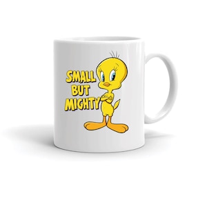 May include: White ceramic mug featuring the cartoon character Tweety Bird with the text "SMALL BUT MIGHTY" in yellow and purple. Tweety is yellow with blue eyes and orange feet. The mug has a curved handle.