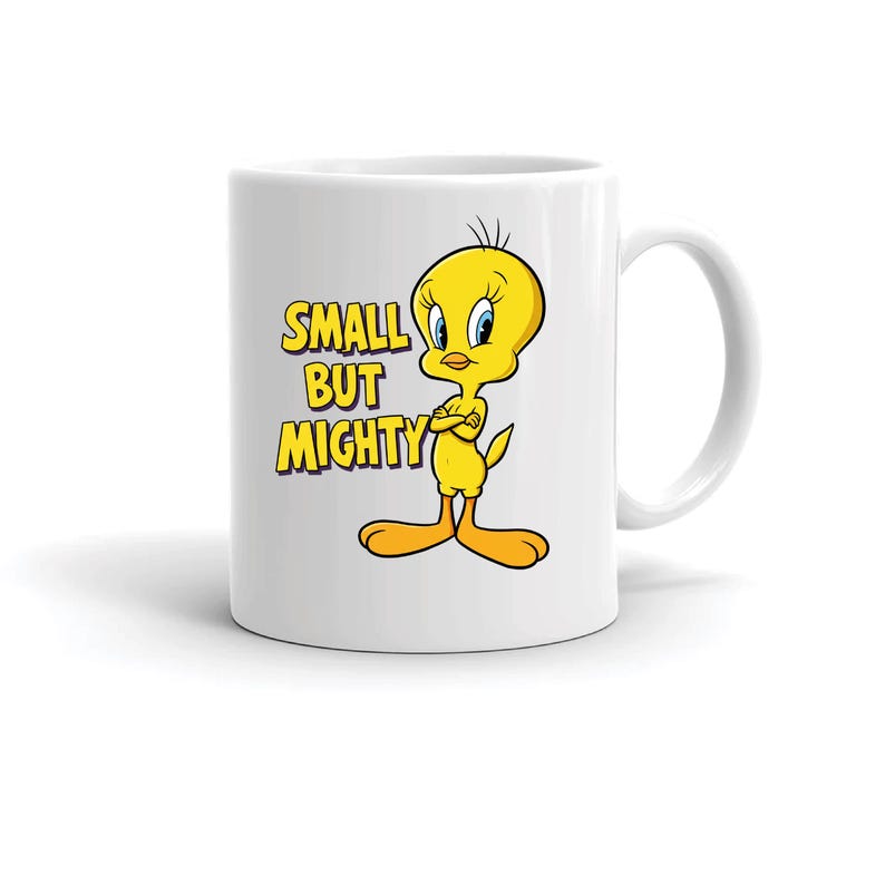 May include: White ceramic mug featuring the cartoon character Tweety Bird with the text "SMALL BUT MIGHTY" in yellow and purple. Tweety is yellow with blue eyes and orange feet. The mug has a curved handle.