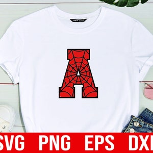 K&ouml;nnte beinhalten: Wei&szlig;es T-Shirt mit einem schwarzen Buchstaben A, gef&uuml;llt mit einem roten und schwarzen Spinnennetz-Design. Das Shirt liegt auf einem wei&szlig;en Holzgrund. SVG, PNG, EPS und DXF Dateien sind unter dem Shirt aufgelistet.
