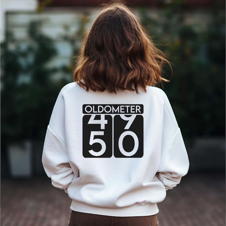 May include: White sweatshirt with black text that reads "Oldometer 49 50".