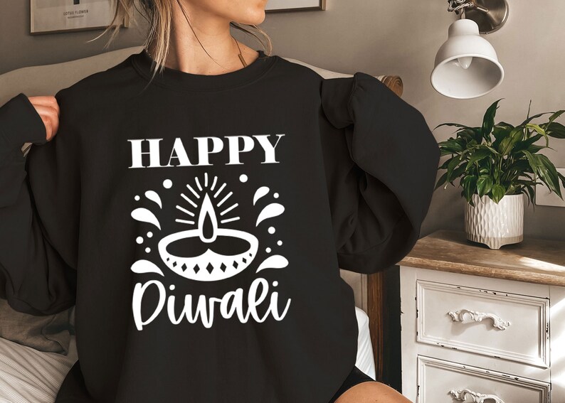 A woman wearing a black sweater with white text and a white candle icon on it