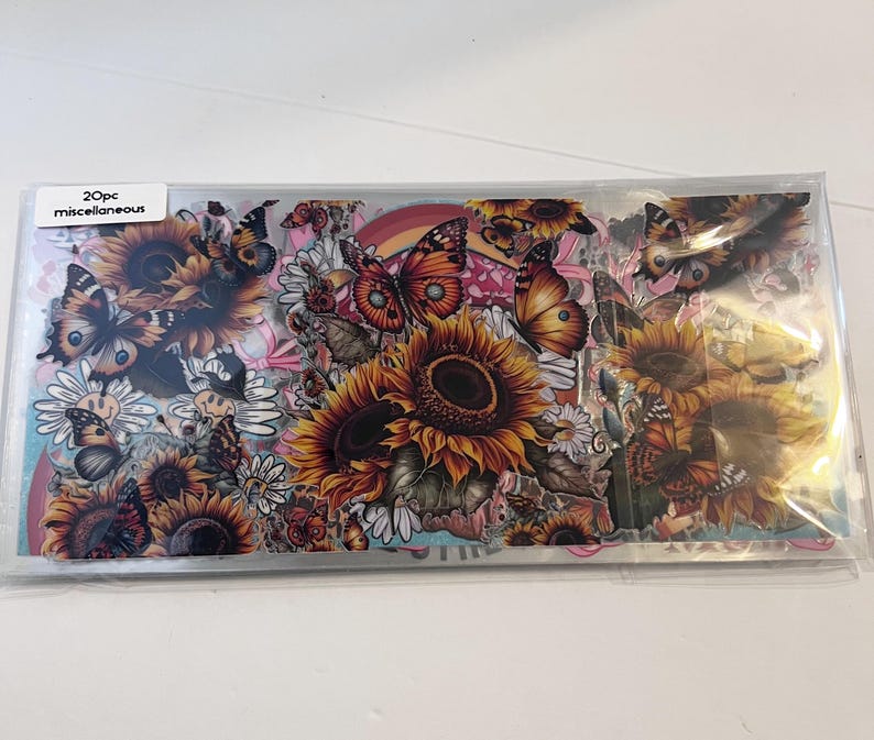 Peut inclure: Une feuille de 20 autocollants assortis repr&eacute;sentant des tournesols, des papillons et d'autres motifs floraux. Les autocollants sont imprim&eacute;s sur un fond transparent et sont parfaits pour ajouter une touche de fantaisie &agrave; votre agenda, votre journal ou votre ordinateur portable.