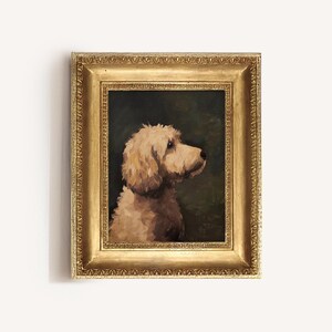 Op de afbeelding: Een ingelijst olieverfschilderij van een lichtbruine hond met zijn hoofd naar de zijkant gedraaid. De hond is geplaatst tegen een donkergroene achtergrond. De lijst is goudkleurig met een decoratieve rand.