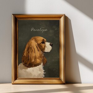 May include: A framed portrait of a dog, featuring a brown and white Cavalier King Charles Spaniel. The dog is painted in a classical style, with the name "Penelope" written above. The frame is gold-colored.