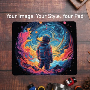 May include: A colorful mousepad with a swirling galaxy design and an astronaut standing in front of it. The astronaut is wearing a blue and black spacesuit and a helmet. The mousepad is perfect for adding a touch of space to your desk.