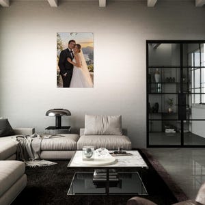 May include: A rectangular acrylic wall print featuring a wedding photograph of a couple in formal attire. The groom wears a black suit and the bride wears a white gown with a veil. The background shows a coastal landscape at sunset.