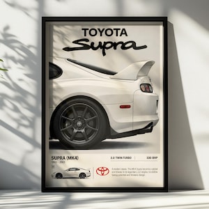 May include: A framed poster featuring a white Toyota Supra MK4. The top displays the text Toyota Supra. The bottom includes the text Supra (MK4) 1993-2002, 3.0 Twin-Turbo, 330 BHP, a small side profile image of the car, and a Toyota logo.