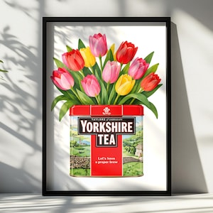 Peut inclure: Une impression encadrée représentant un bouquet de tulipes rouges, roses et jaunes sortant d'une boîte de thé Yorkshire rectangulaire. La boîte présente une illustration de paysage, le texte Taylors of Harrogate, Yorkshire Tea et Let's have a proper brew.