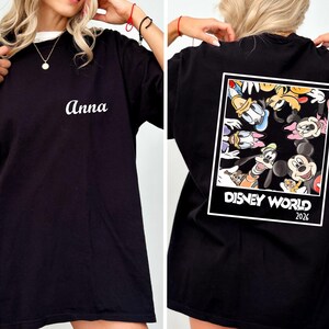 a person wearing a black t-shirt with a Disney World-themed design on the back.
