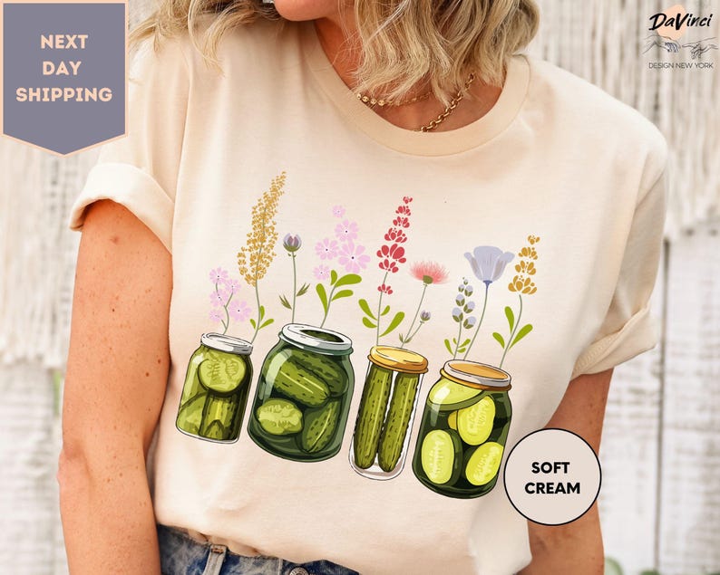 a woman wearing a t - shirt with pickles in jars