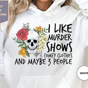 a woman wearing a white hoodie that says i like murder shows and maybe 3
