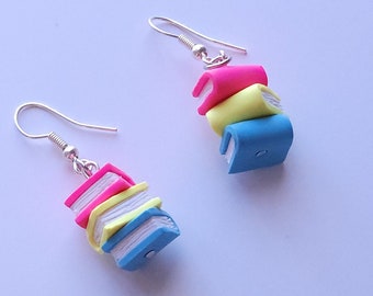 May include: A pair of silver dangle earrings with a stack of three colorful polymer clay books. The books are pink, yellow, and blue.