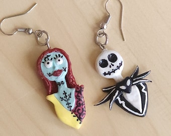 May include: A pair of handmade polymer clay earrings featuring Jack Skellington and Sally from the Nightmare Before Christmas. The earrings are painted in their signature colors, with Jack in black and white and Sally in blue, yellow, and red.