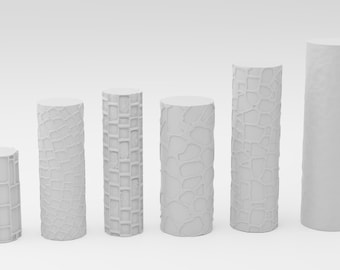 May include: Six white cylindrical pedestals with different textured surfaces. The pedestals are arranged in a row from smallest to largest.