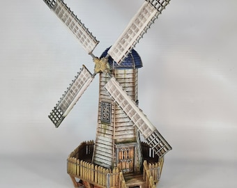 May include: A detailed miniature windmill with four white and beige blades. The wooden structure features a blue roof, a small window, and a wooden fence. The windmill is a decorative item, likely for a home or garden.