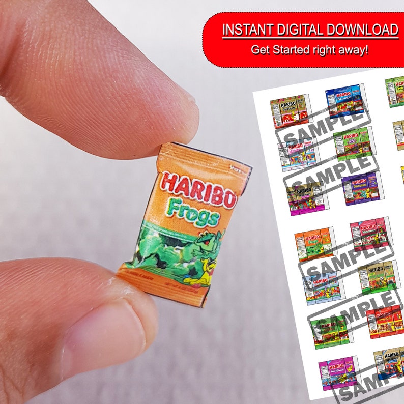May include: A miniature replica of a HARIBO Frogs candy bag. The bag is orange and yellow with a green frog graphic and the text "HARIBO Frogs".