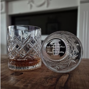 May include: Two clear crystal whisky glasses featuring a diamond-cut pattern. One glass is upright, and the other is placed on its side, revealing an engraving on the base that reads: For the Man Who Poured His Heart into Us Happy 60th Birthday Dad.