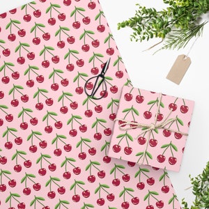 May include: Pink wrapping paper with a repeating pattern of red cherries with green stems and leaves.