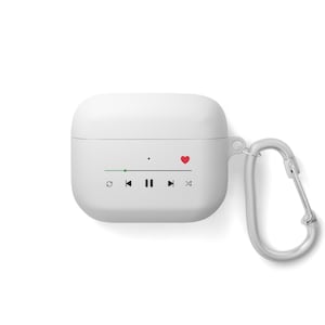 Puede incluir: Funda blanca para Airpods con un corazón rojo y controles de reproductor de música impresos en la parte delantera. La funda tiene un mosquetón plateado.