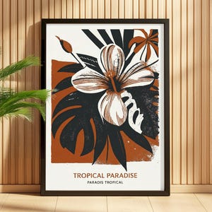 Peut inclure: Une affiche encadrée avec un motif floral tropical. Elle présente une grande fleur d'hibiscus blanche et marron, des feuilles vert foncé et un fond couleur rouille. Le texte "TROPICAL PARADISE" est affiché en bas.
